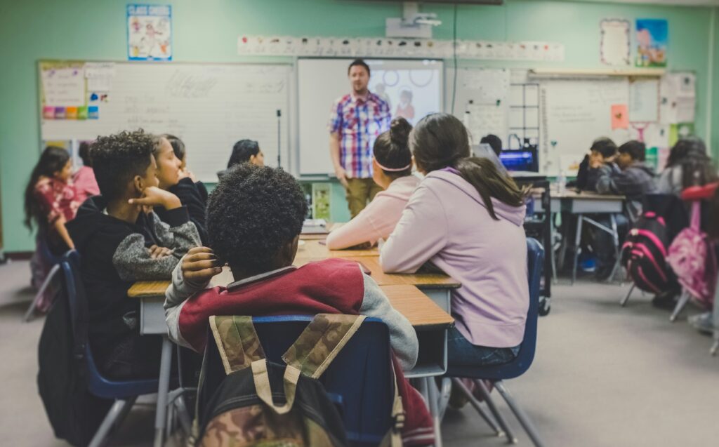 long-term substitute teacher standing in front of classroom full of students