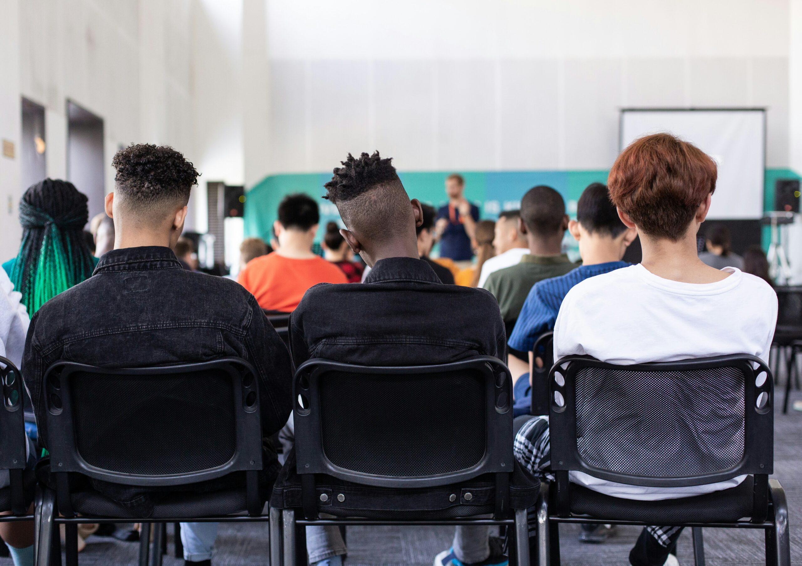 Students sitting in the back of a classroom watching a lecture