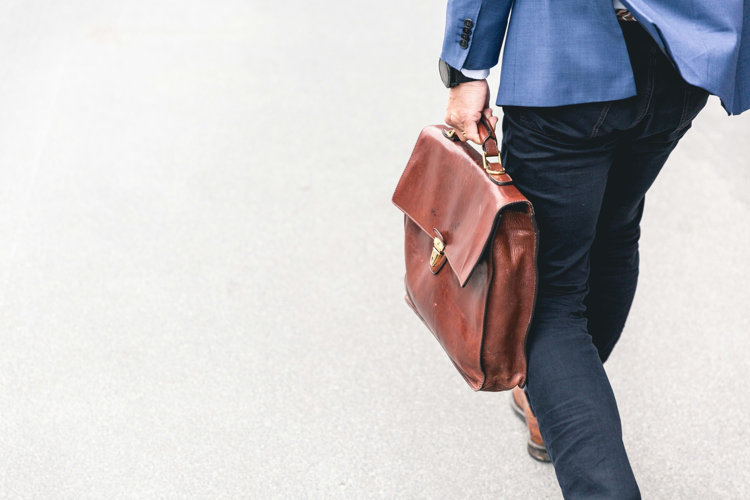 A teacher walking with their briefcase